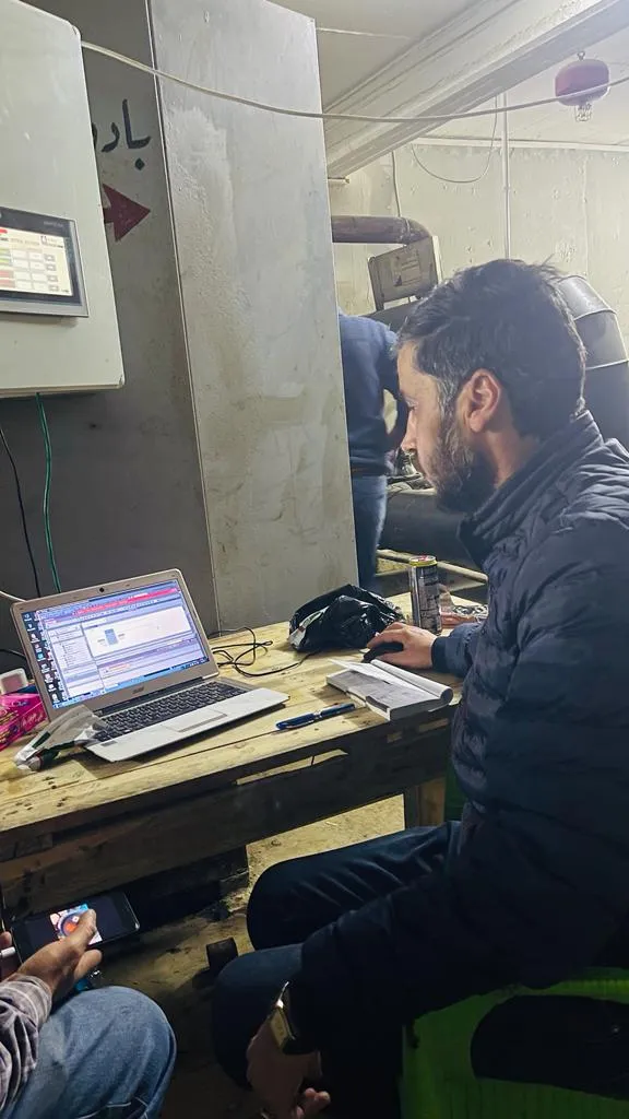 Engineer configuring the flowmeter system on a laptop at the oil field